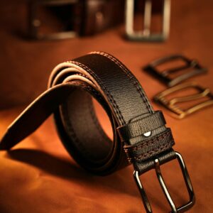 Luxurious men's leather belt displayed elegantly with various belt buckles.