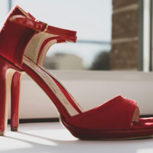 A stylish photo of red high heels by a window capturing elegance and fashion essence.