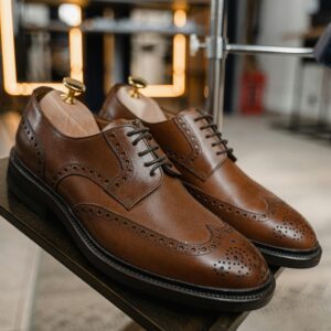 Pair of classic brown leather brogue shoes showcased in a stylish setting.
