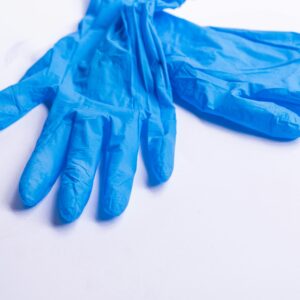 Pair of blue nitrile disposable gloves resting on a clean white surface.